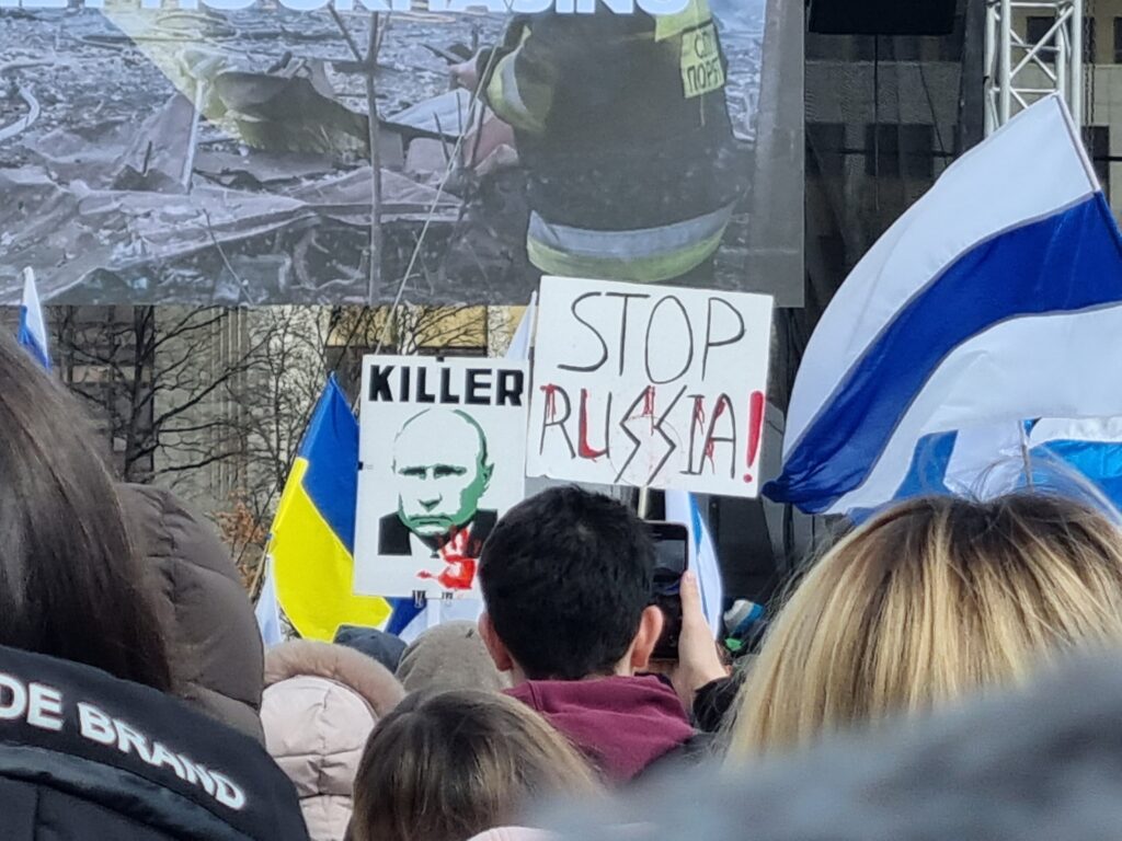 люди тримають плакати з закликом зупинити росію